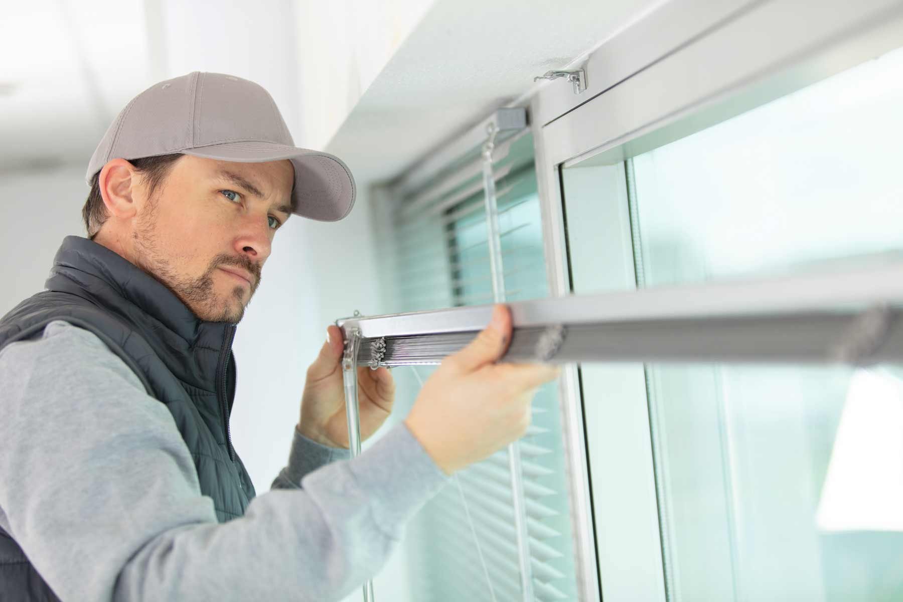 homeguide-worker-installing-window-blinds-in-a-home